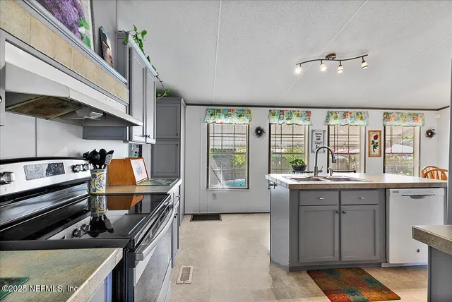 a kitchen with a large window and stainless steel appliances