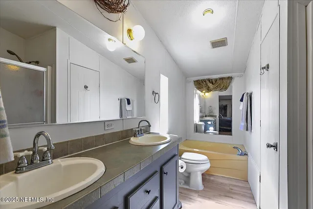 a bathroom with a granite countertop sink a toilet and a large mirror