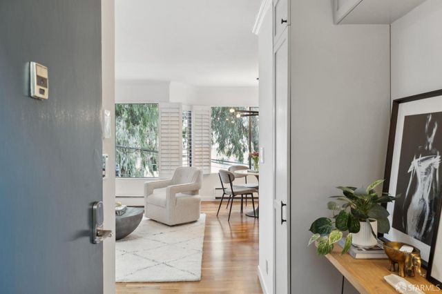 a living room with furniture floor to ceiling window and a potted plant