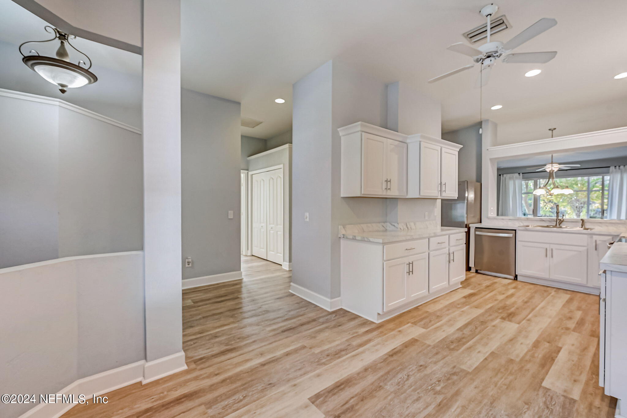 1308 Asher Court Ormond Beach, FL 32174 - Photo 8 of 40 a large kitchen with cabinets wooden floor and stainless steel appliances