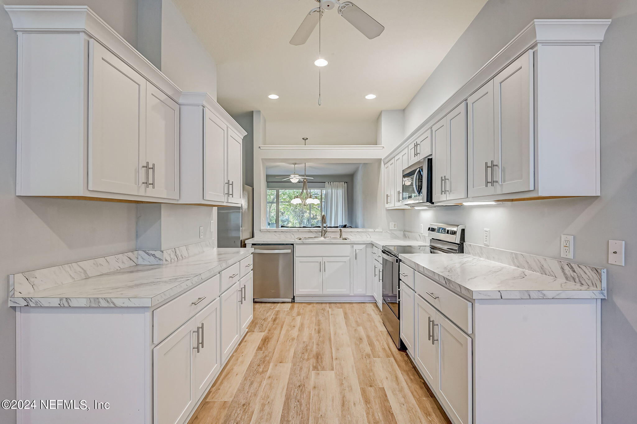 1308 Asher Court Ormond Beach, FL 32174 - Photo 9 of 40 a kitchen with granite countertop white cabinets sink and stainless steel appliances