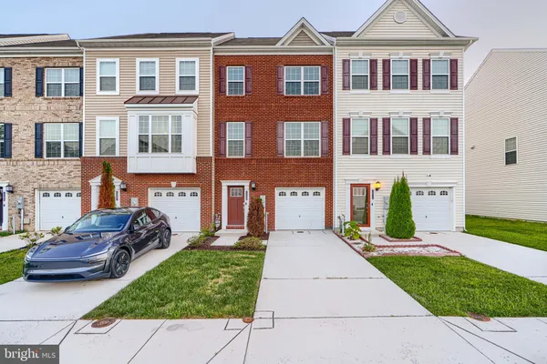 a front view of a house with a yard and potted plants