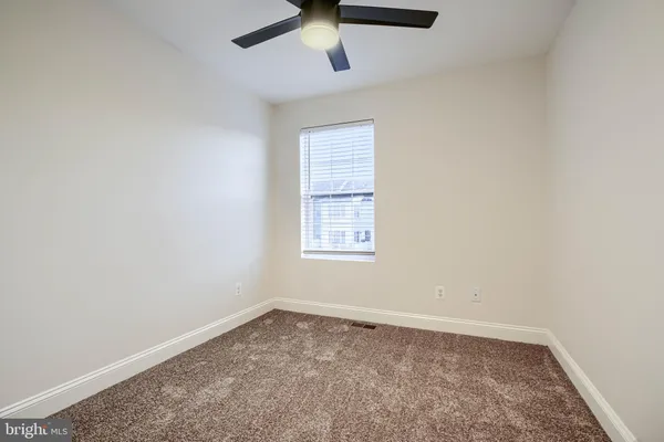 an empty room with a window and a ceiling fan