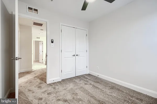 an empty room with closet and windows