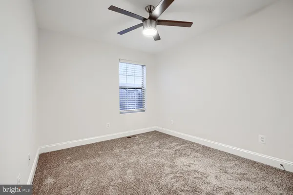 an empty room with a window and a fan