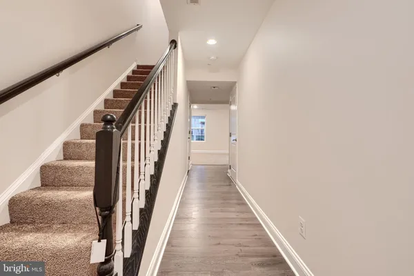a view of a hallway with wooden floor and stairs
