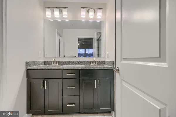 a bathroom with a granite countertop sink and a mirror