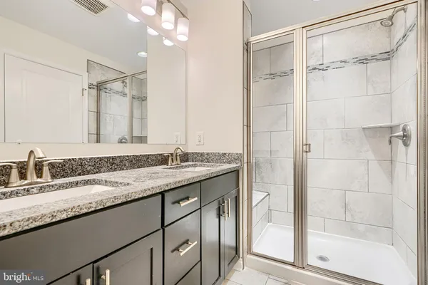 a bathroom with a granite countertop sink mirror and double