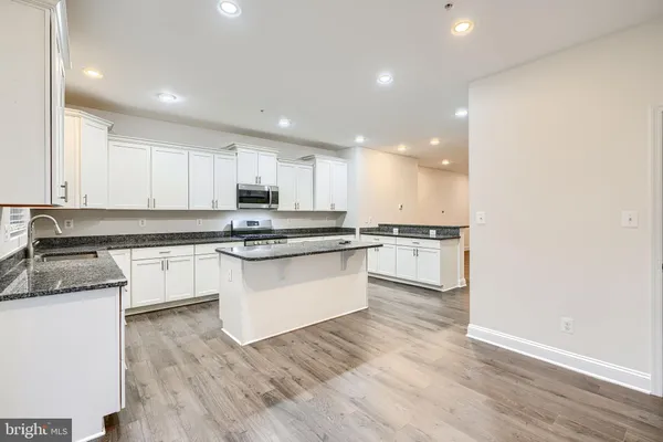 a kitchen with granite countertop white cabinets and white appliances