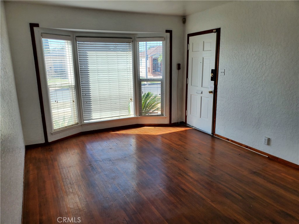 1420 South Butler Avenue Compton, CA 90221 - Photo 13 of 44 an empty room with wooden floor and windows
