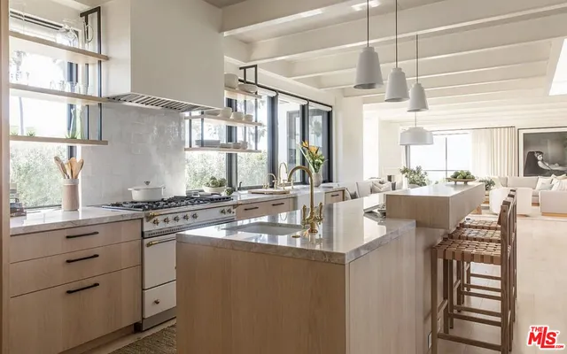 a kitchen with kitchen island granite countertop a sink cabinets stainless steel appliances and a counter top space