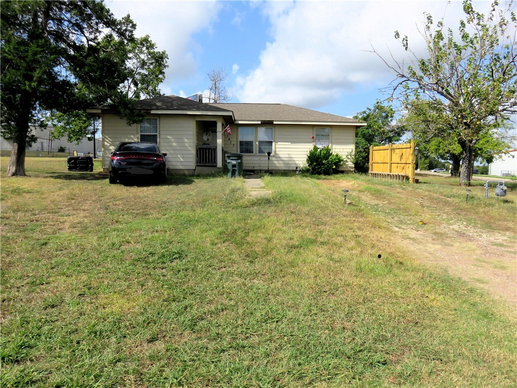 a front view of a house with a garden and trees