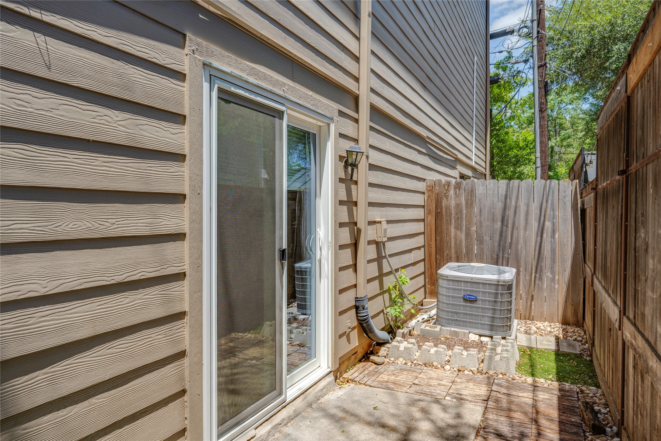 3627 Menchaca Road, Unit 108 Austin, TX 78704 - Photo 22 of 24 Sliding glass doors open directly to a private, fenced outdoor patio area.