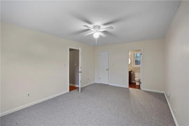 an empty room with a ceiling fan and a window