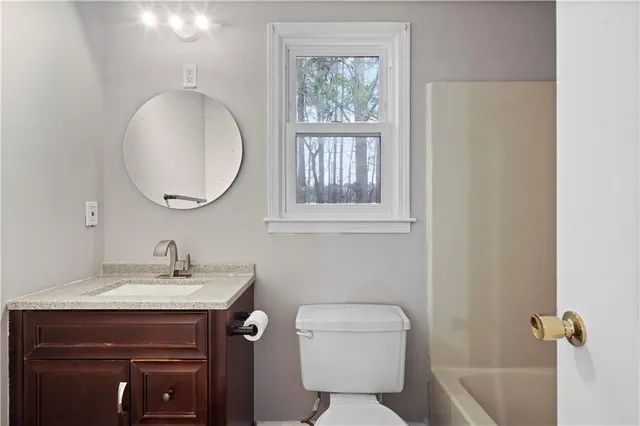 a bathroom with a toilet a sink and mirror