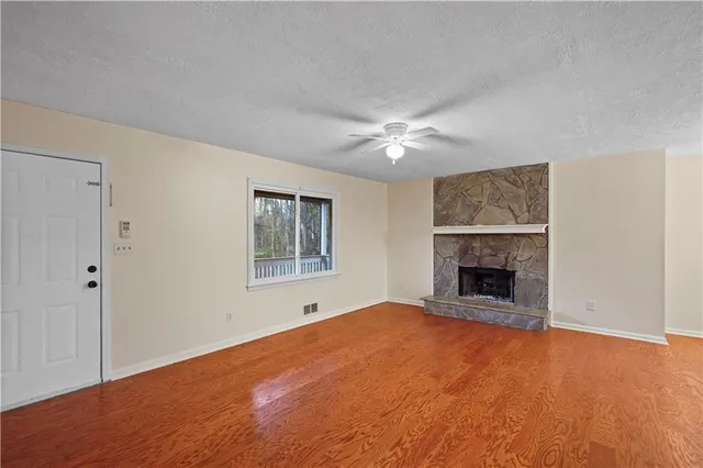 a view of empty room with a fireplace and window