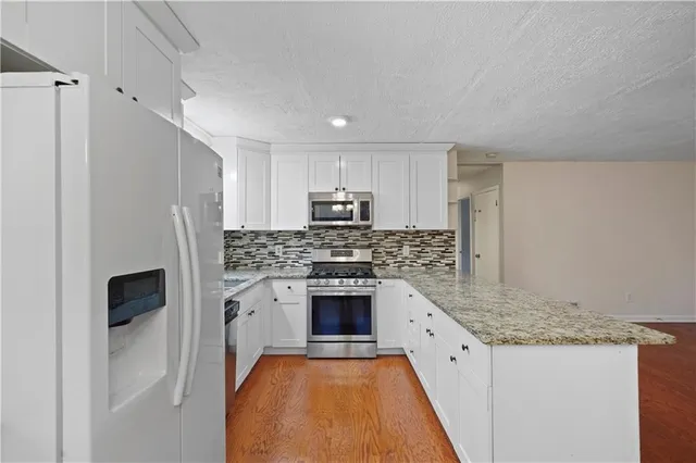 a kitchen with stainless steel appliances granite countertop a stove a sink and a refrigerator