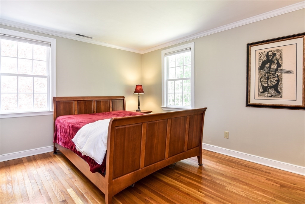 114 Hunters Ridge Road Concord, MA 01742 - Photo 25 of 38 a bedroom with a bed and wooden floor