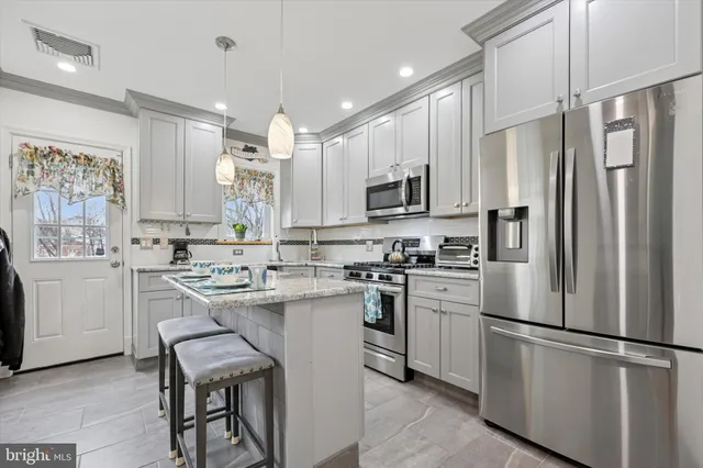 a kitchen with white stainless steel appliances a refrigerator sink and microwave