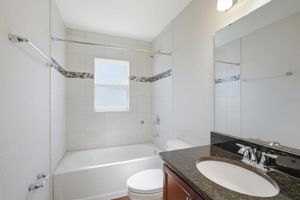 212 Serena Ridge Drive Seffner, FL 33584 - Photo 17 of 22 a bathroom with a granite countertop sink toilet a mirror and shower