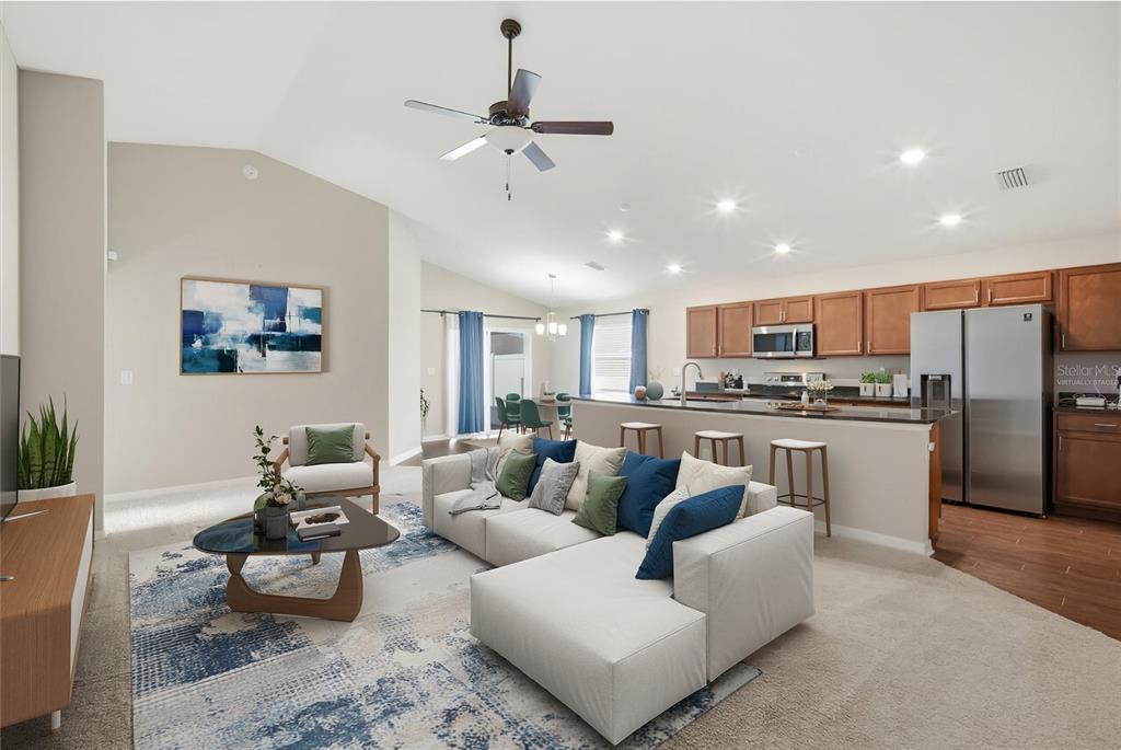 212 Serena Ridge Drive Seffner, FL 33584 - Photo 3 of 22 a living room with white couches and kitchen view with wooden floor
