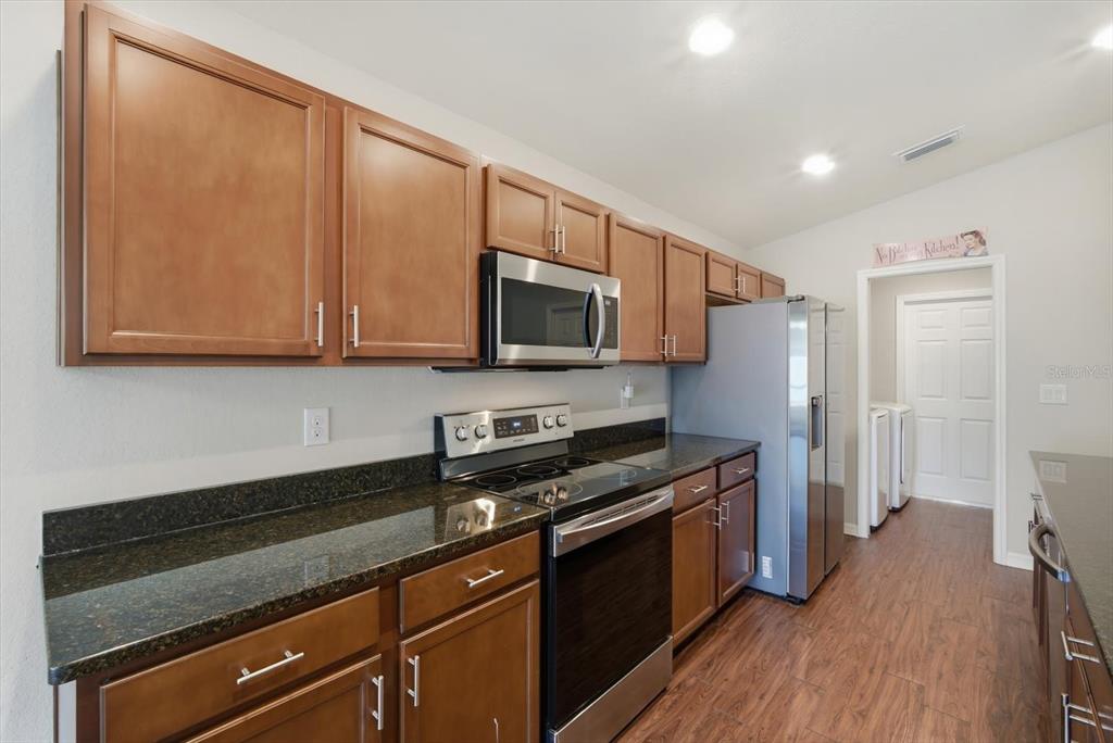 212 Serena Ridge Drive Seffner, FL 33584 - Photo 10 of 22 a kitchen with stainless steel appliances granite countertop a stove a sink and a microwave