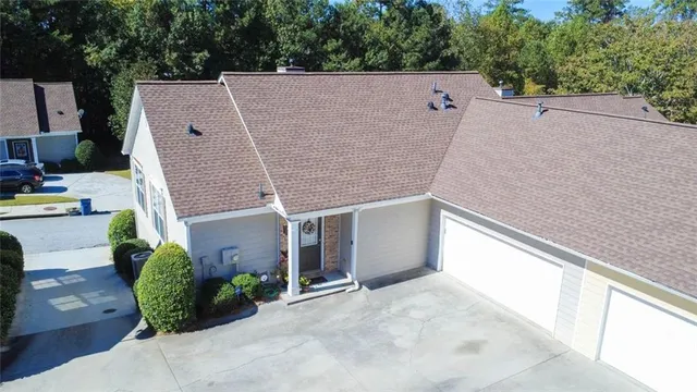 a aerial view of a house with a yard and a large tree