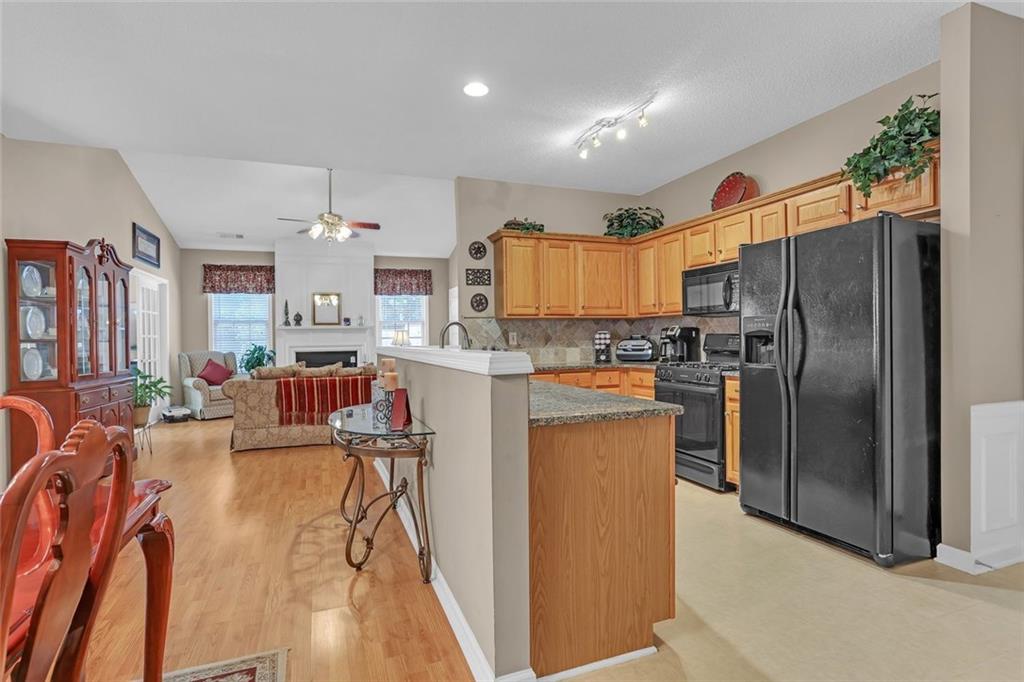314 Gable Brook Drive Southwest Grayson, GA 30017 - Photo 15 of 26 a kitchen with stainless steel appliances a refrigerator a stove a sink dishwasher and a dining table with wooden floor