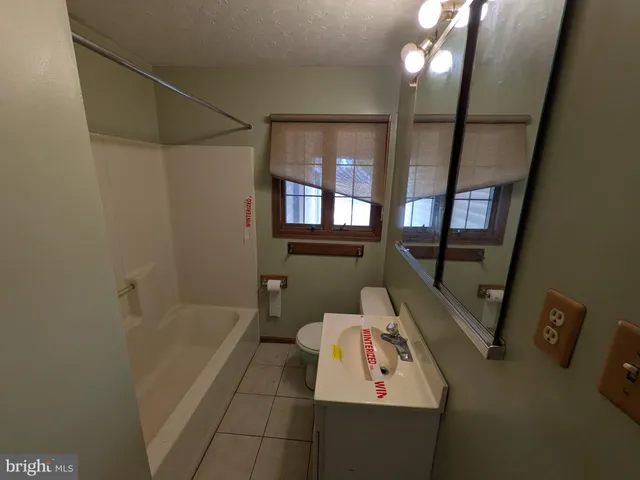 a bathroom with a bathtub sink and mirror