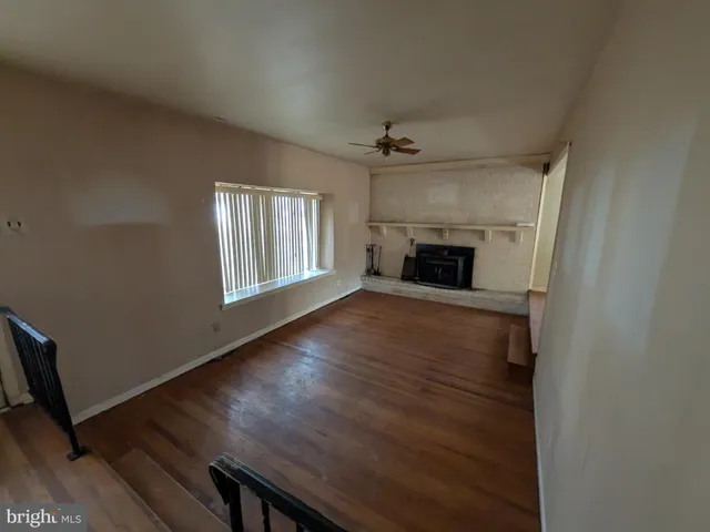 an empty room with windows and fireplace