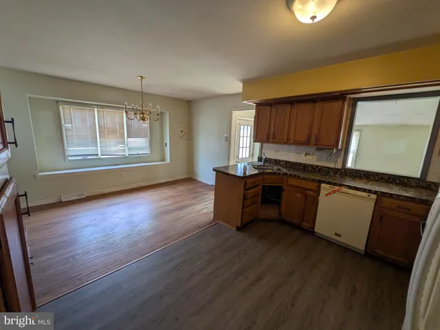 a kitchen with granite countertop wooden floors and white stainless steel appliances