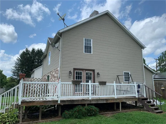 a front view of house with deck and garden