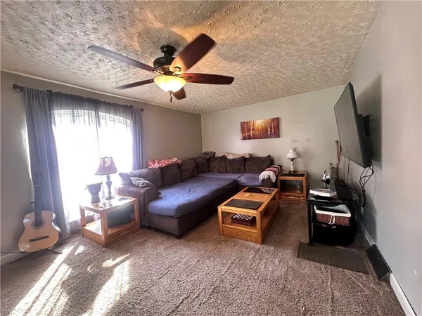 a living room with furniture a chandelier and a flat screen tv