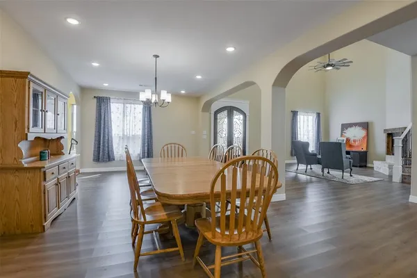 a dining room with furniture a chandelier and wooden floor