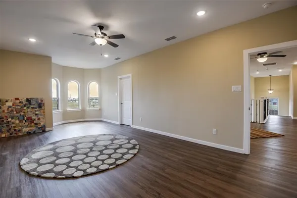 a view of a livingroom with wooden floor and a ceiling fan