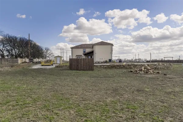 a view of a dry yard with wooden fence