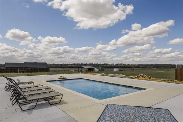a view of swimming pool with outdoor seating and lake