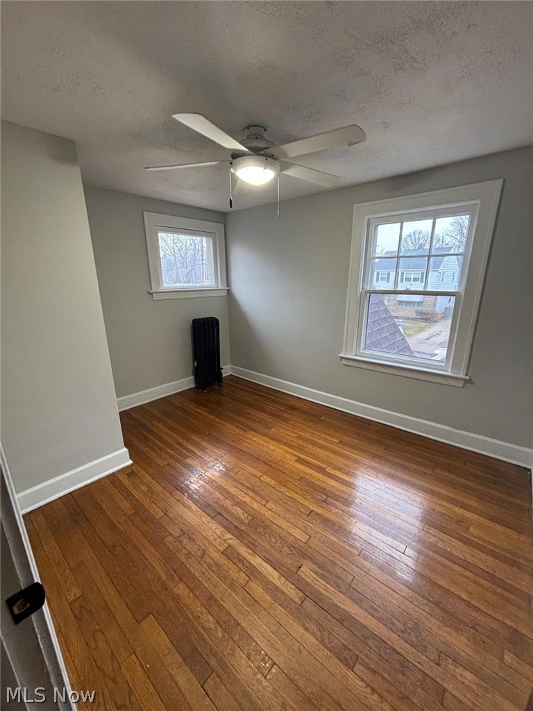 3808 Kirkwood Road Cleveland Heights, OH 44121 - Photo 3 of 6 Spare room with dark wood-style flooring, a textured ceiling, and a ceiling fan