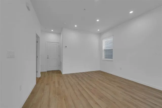 a view of an empty room with wooden floor