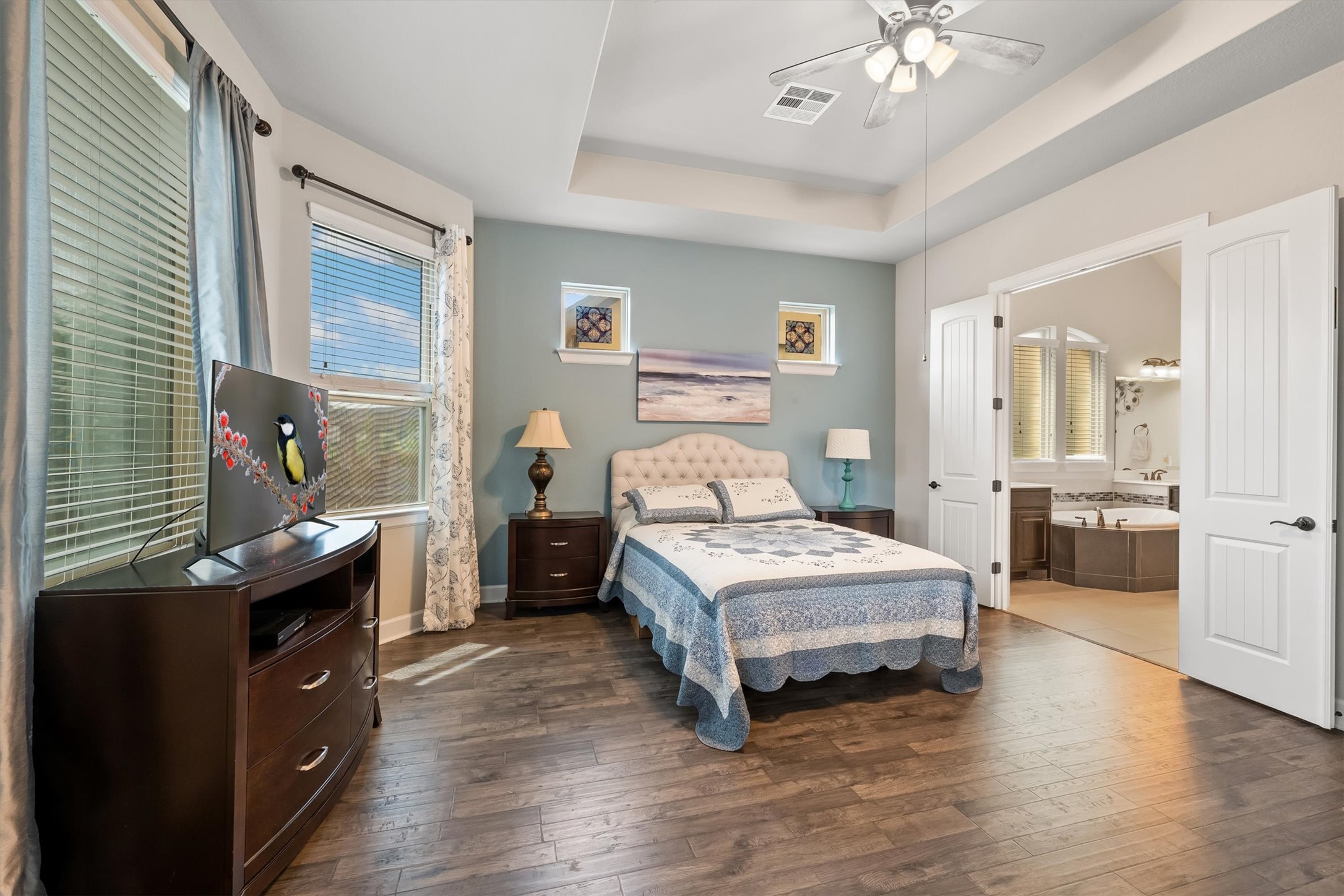 1004 Hezekiah Lane Leander, TX 78641 - Photo 16 of 36 Spacious room featuring wood-finish flooring, a tray ceiling, and a ceiling fan