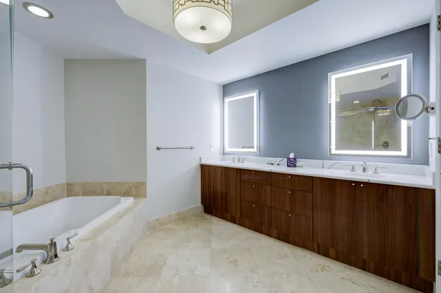 a bathroom with a tub sink and mirror