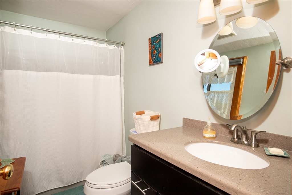 663 Wareham Street, Unit 8 Middleboro, MA 02346 - Photo 17 of 27 a bathroom with a granite countertop sink a toilet and a mirror
