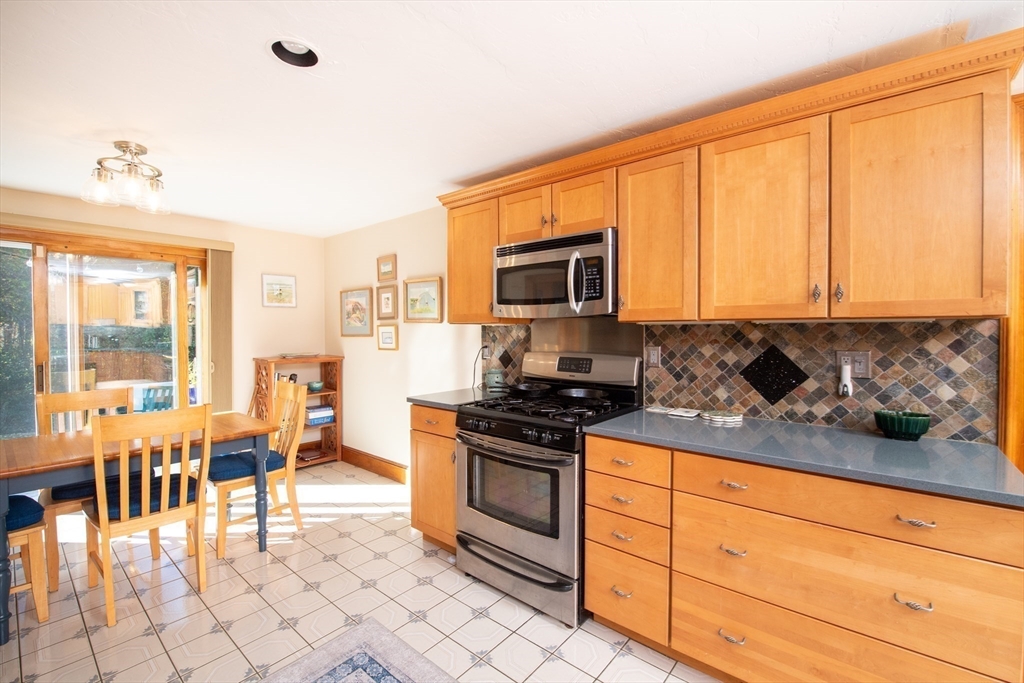 663 Wareham Street, Unit 8 Middleboro, MA 02346 - Photo 10 of 27 a kitchen with stainless steel appliances granite countertop a stove top oven a sink dishwasher a dining table and chairs with wooden floor