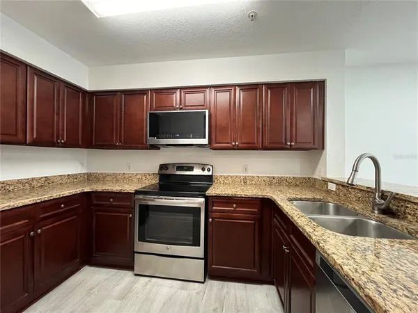 a kitchen with stainless steel appliances granite countertop a sink stove and microwave