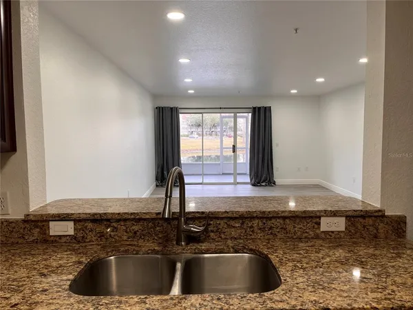 a kitchen with sink a window and couch