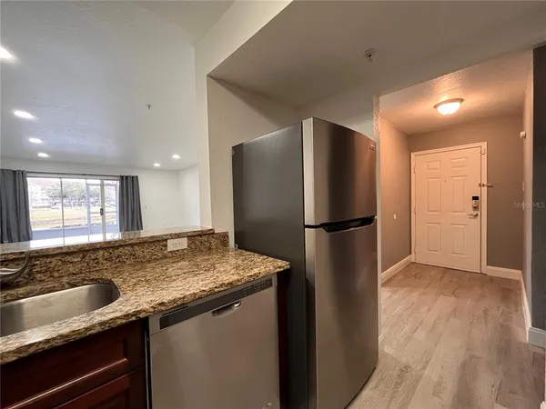 a kitchen with stainless steel appliances granite countertop a refrigerator and a sink