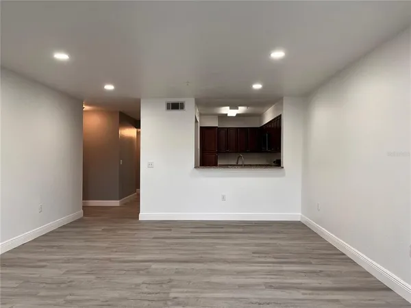 a view of an empty room with wooden floor