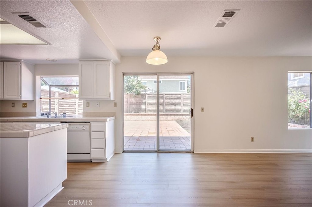 629 Calaveras Road San Dimas, CA 91773 - Photo 11 of 49 a open hall with stainless steel appliances granite countertop a stove and white cabinets with wooden floor