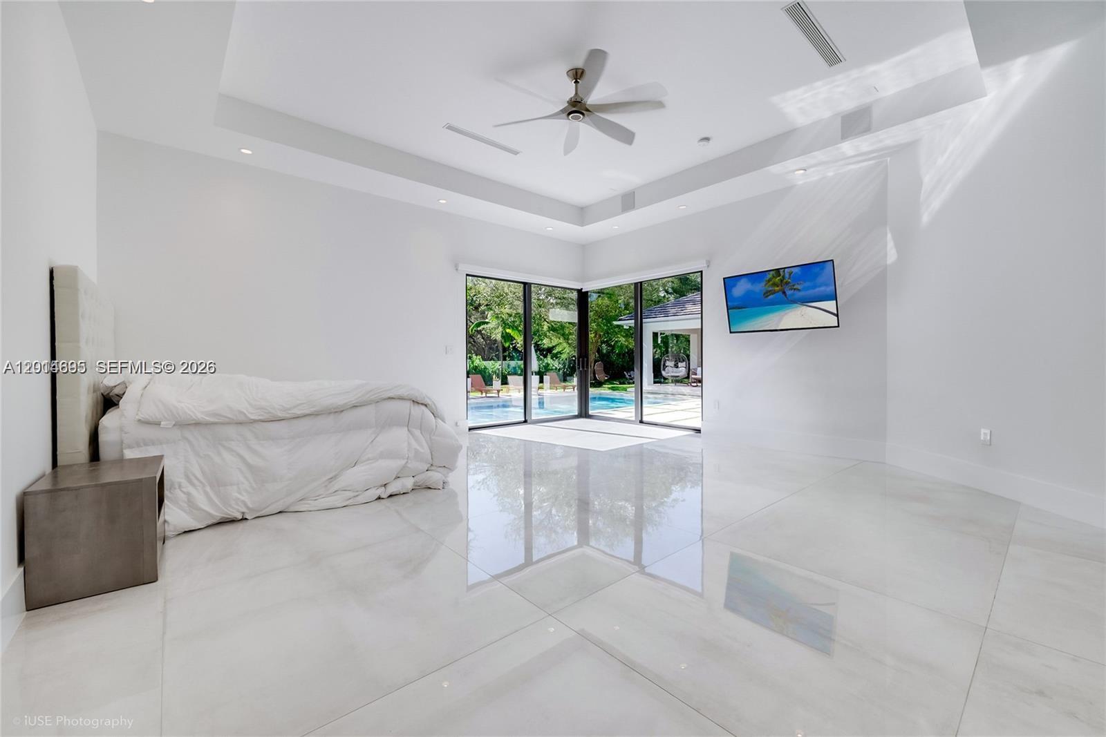 7830 Southwest 117th Street Pinecrest, FL 33156 - Photo 11 of 24 a spacious bedroom with a large bed and a chandelier