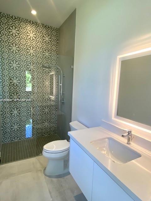 7830 Southwest 117th Street Pinecrest, FL 33156 - Photo 14 of 24 a bathroom with a granite countertop sink a toilet a mirror and shower